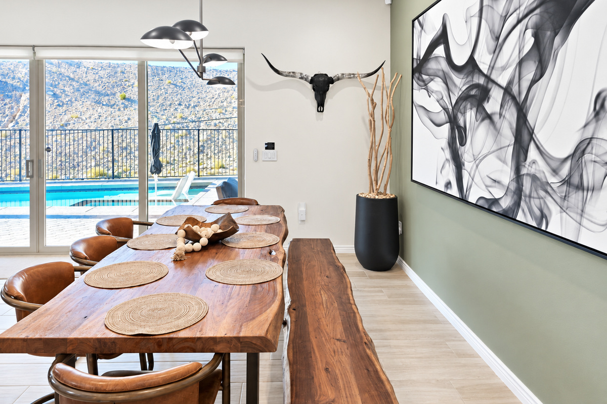 Custom live edge wood dining table with seating for 8 and dramatic Restoration Hardware light fixture creating a sophisticated focal point.