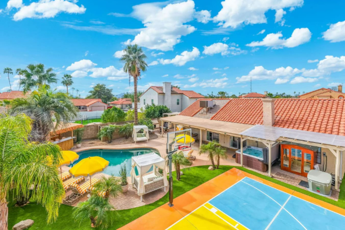 Expansive backyard resort with pool, spa, basketball court, and lush landscaping—an entertainer's dream with desert views.