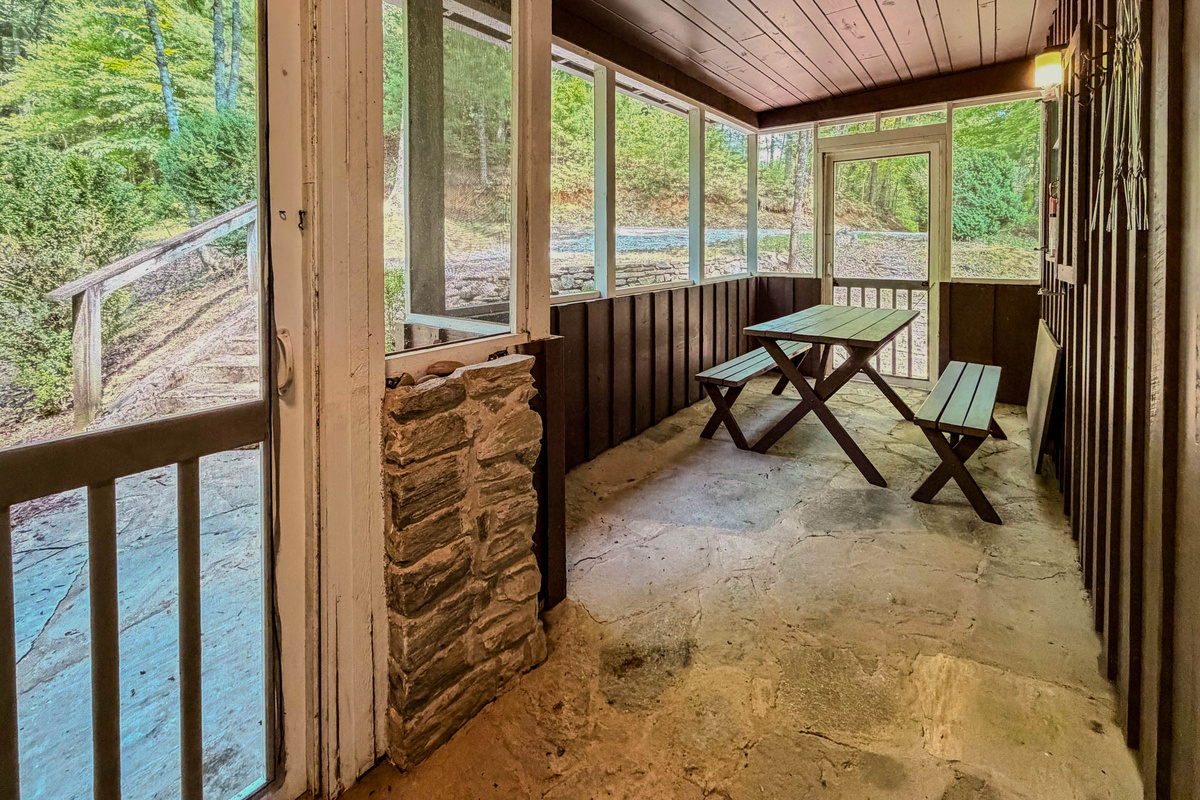The front screened in Porch features a picnic table.
