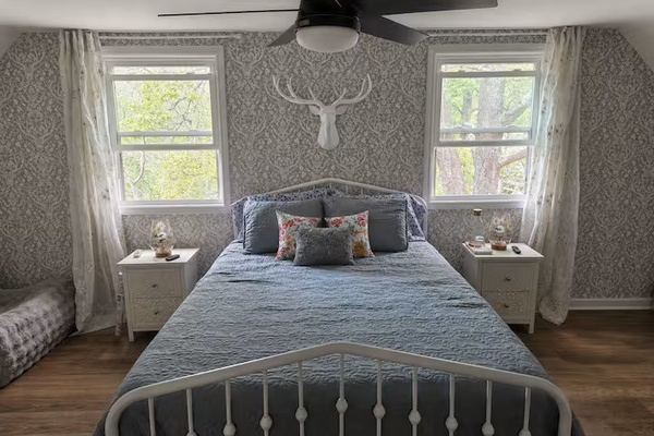 Charming second-floor primary bedroom with a queen bed, natural light and a cozy retreat feel near the upstairs loft and deck.