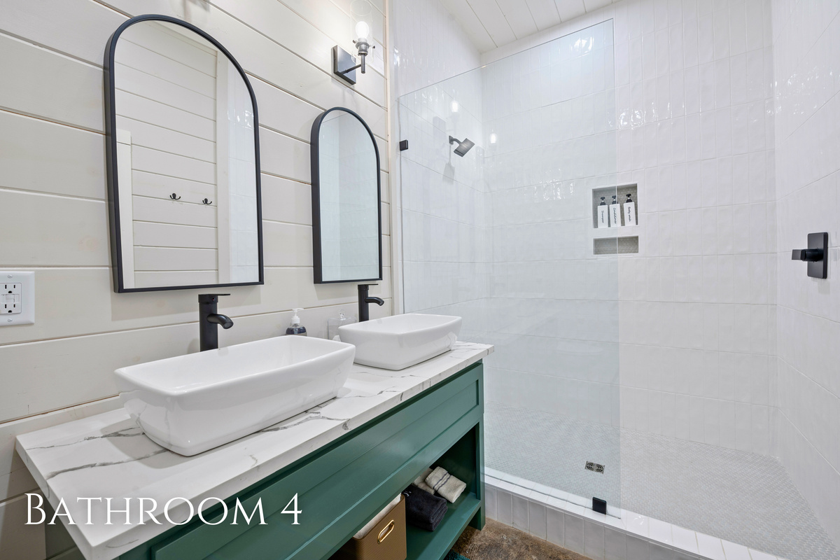 Clean finishes, a spacious walk in shower, and double sinks make this bathroom as practical as it is beautiful.
