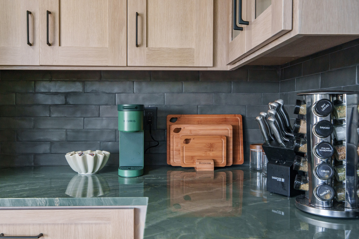 Fully equipped kitchen with modern appliances, generous counter space, and large windows that fill the room with natural light. Coffee station includes Keurig k-cup pods and traditional ground coffee maker