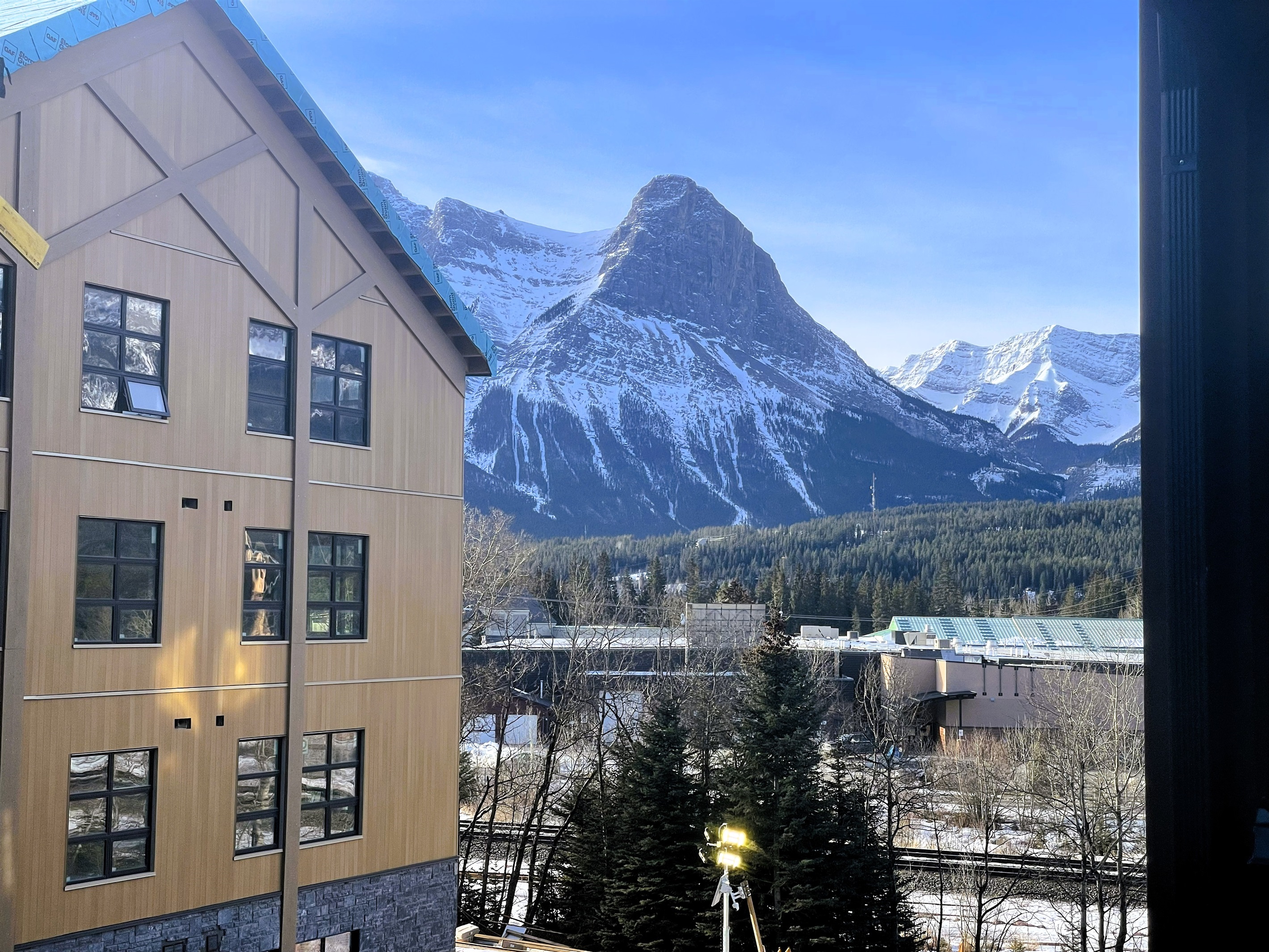 Mountains visible and railroad tracks visible from balcony. 