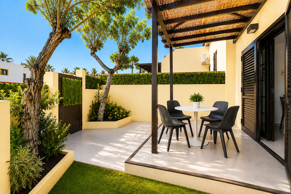 Elegant covered terrace in a private garden setting, featuring a stylish outdoor dining area - ideal for relaxed breakfasts, al fresco dining, and enjoying Fuerteventura’s climate.