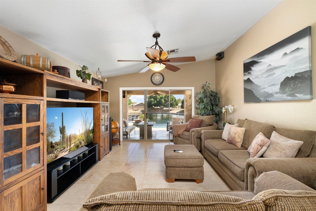 The open living area flows seamlessly from cozy couch to the outdoor oasis beyond — enjoy the pool view right from your seat.