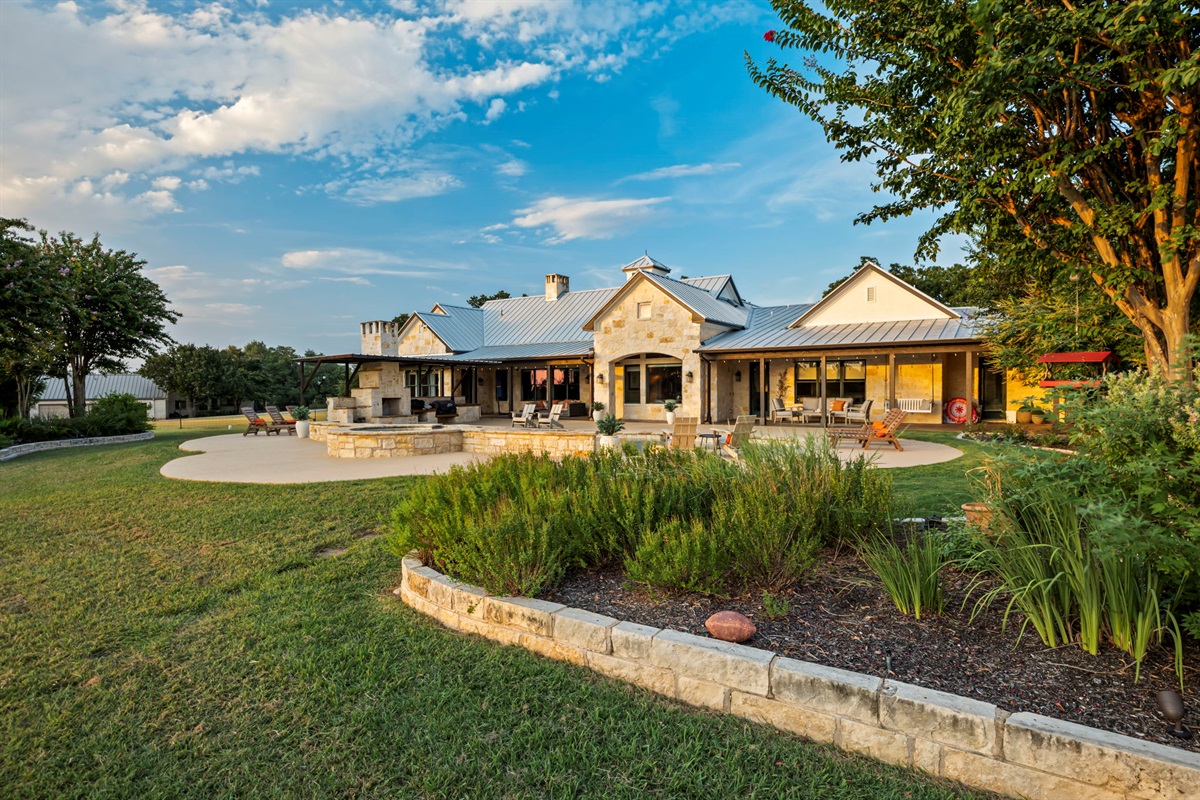 Spacious backyard featuring a stone patio and a lush, well-maintained lawn.