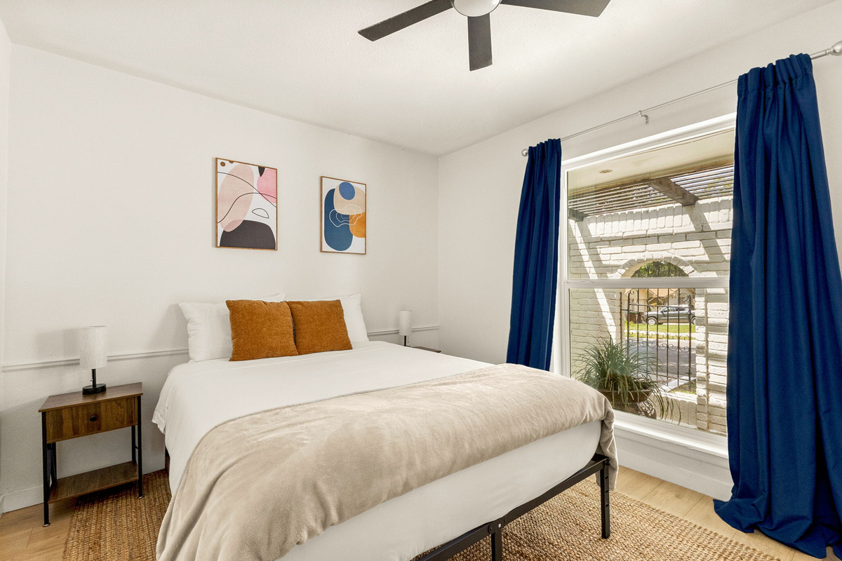 A bright and cozy bedroom featuring a plush king bed, blackout curtains, and a calming space designed for restful nights.