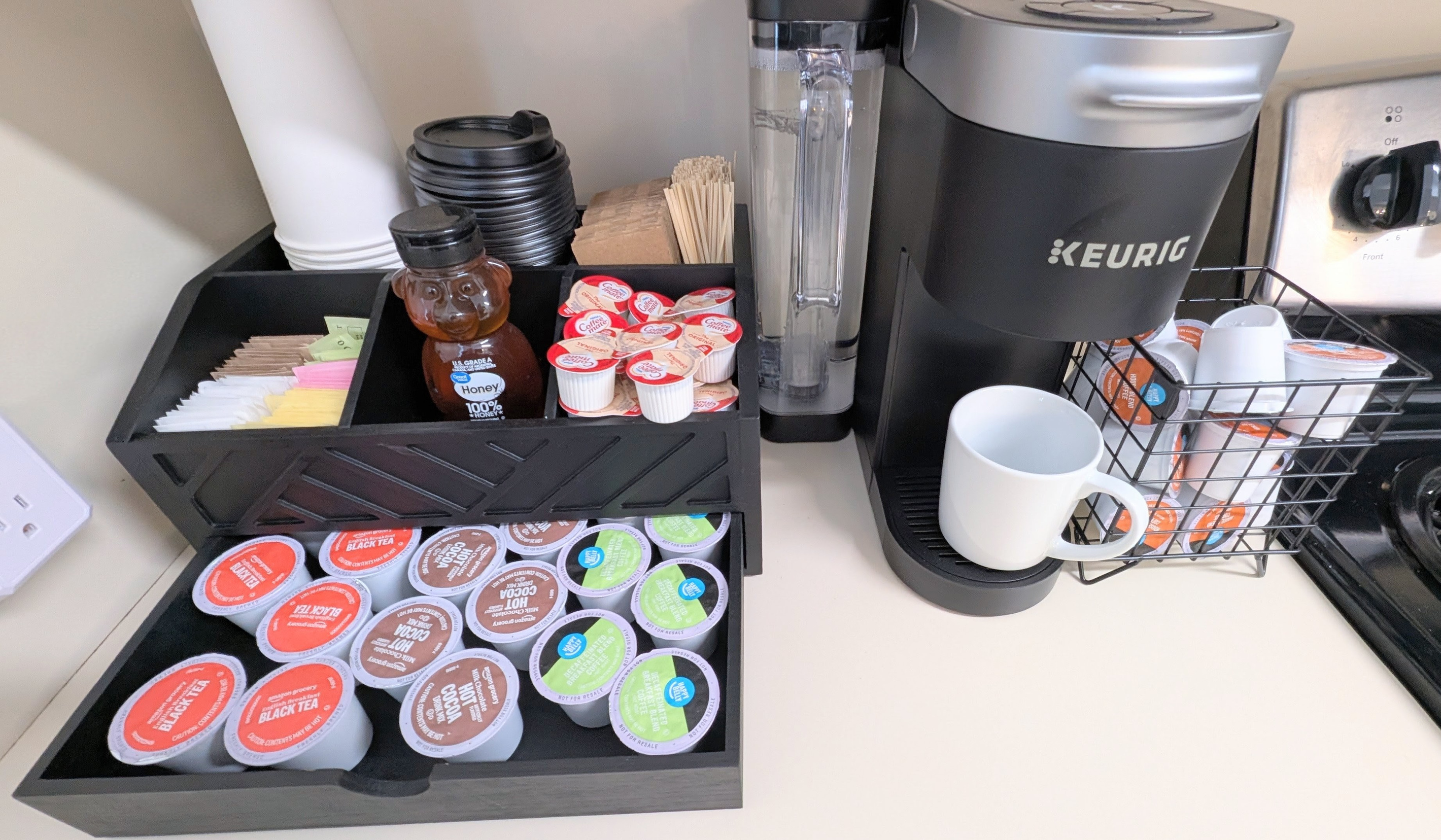 Start your day or wind down with a cozy drink from the stocked coffee bar, offering coffee, decaf, tea, and cocoa, along with mugs and to-go cups.