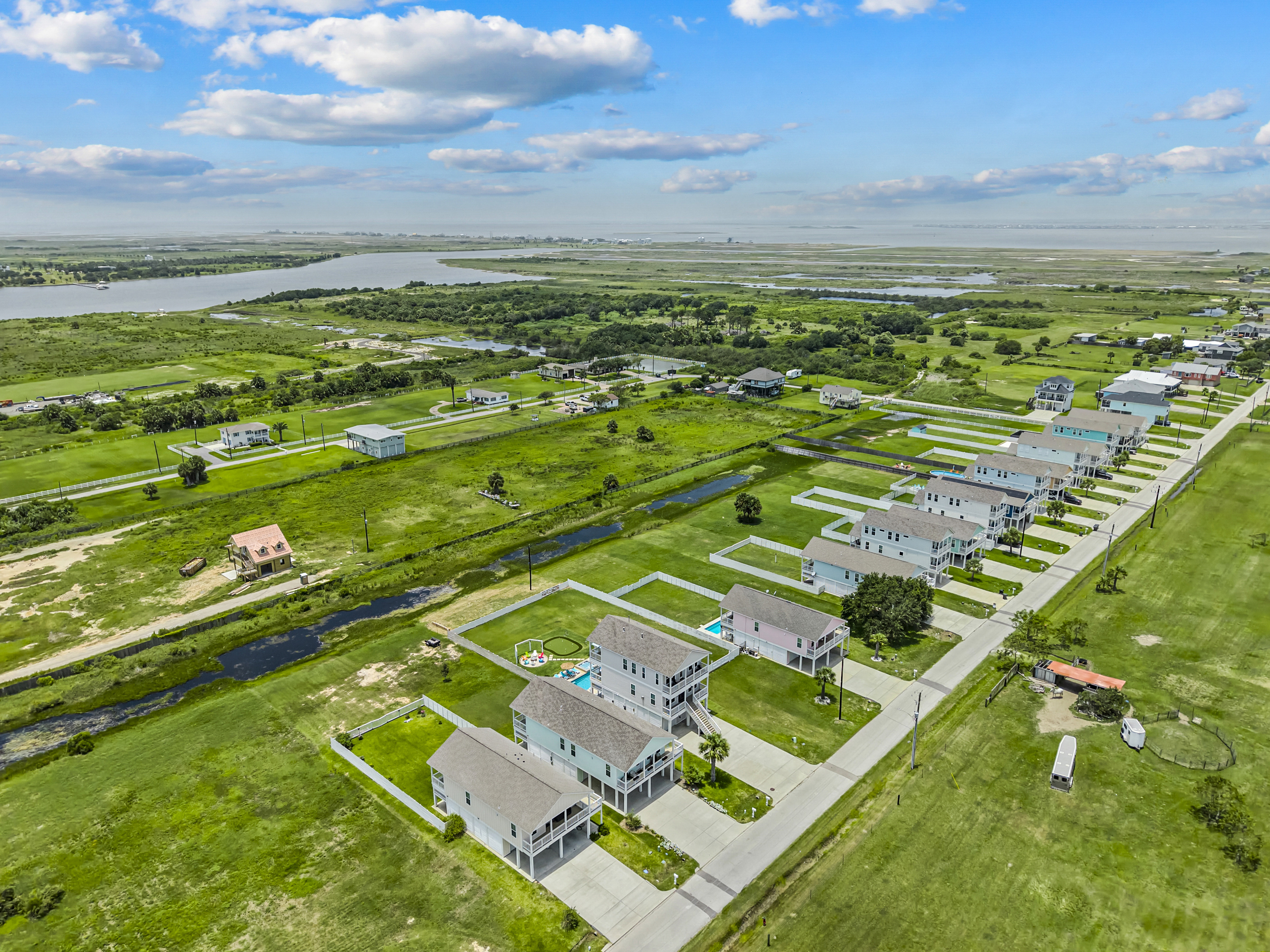 This aerial view showcases the home's prime location near scenic canals and beautiful coastal waters, with the beach just minutes away—perfect for boating, fishing, beach days, and unforgettable Gulf Coast adventures.