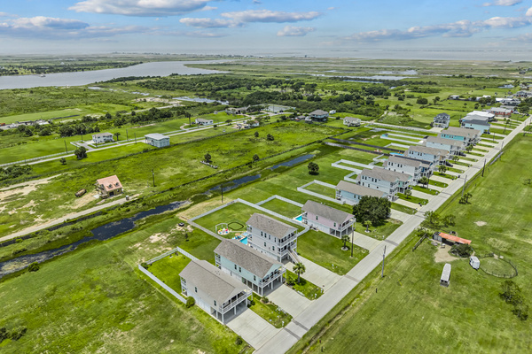 This aerial view showcases the home's prime location near scenic canals and beautiful coastal waters, with the beach just minutes away—perfect for boating, fishing, beach days, and unforgettable Gulf Coast adventures.