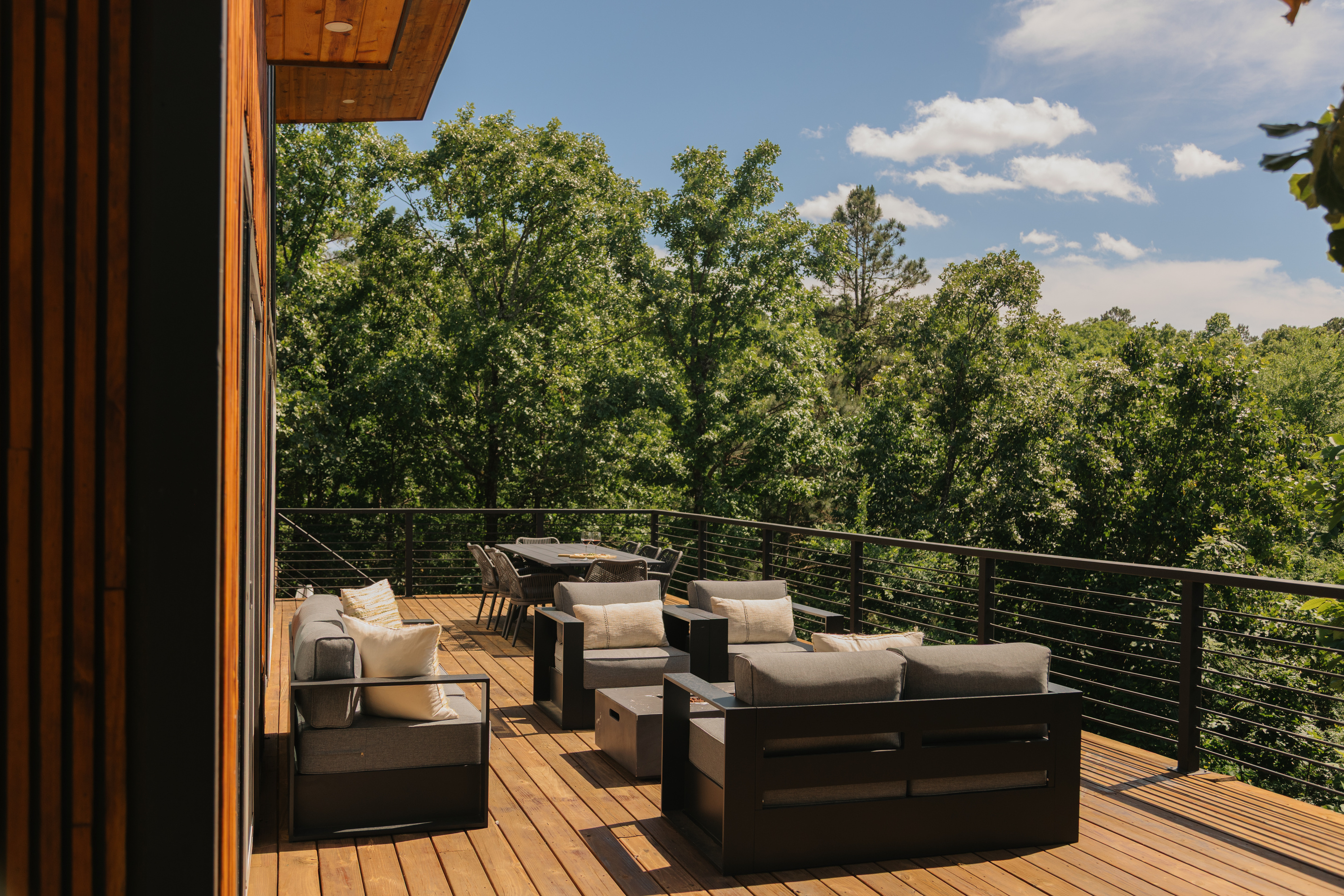 Stunning outdoor deck. Epic views framed by mature hardwood trees. Features a gas-lit firepit for cozy vibes.
