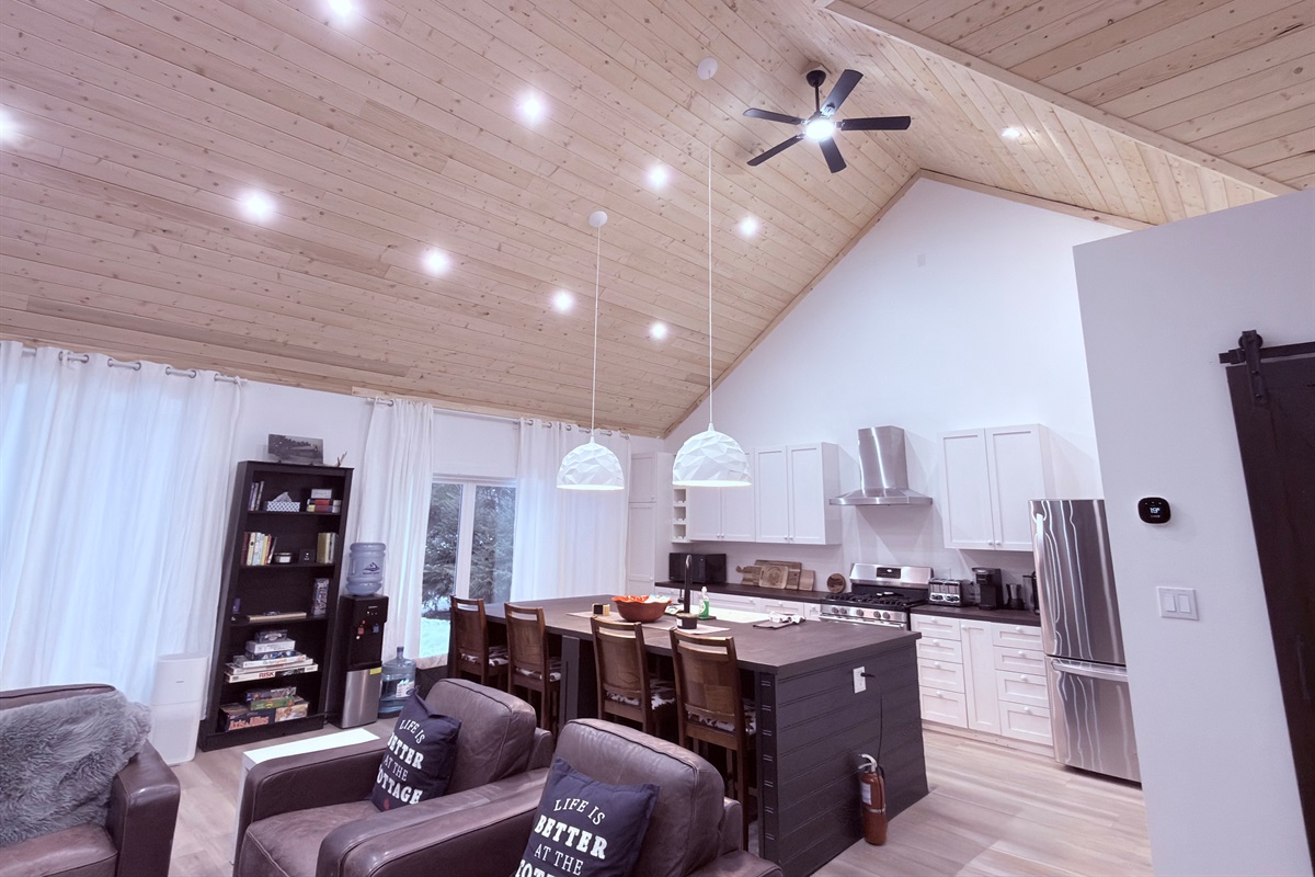 Bright open-concept living space with vaulted cedar ceiling and kitchen