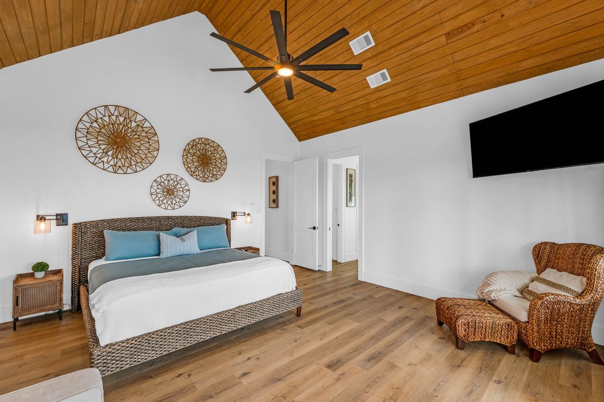 Cair Paravel: Woven wall discs and a matching woven bed frame bring texture to the primary suite, which flows directly into its spa-style ensuite.