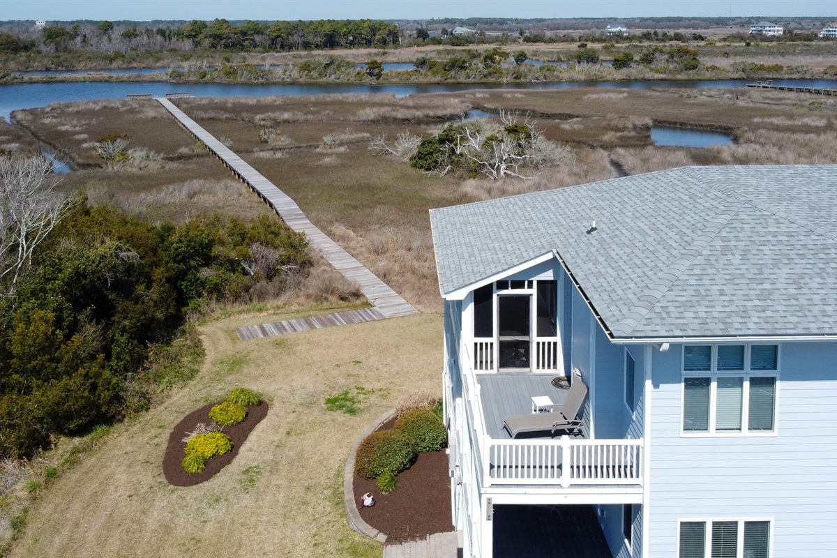 Back deck and screened porch with views of the boardwalk to the dock