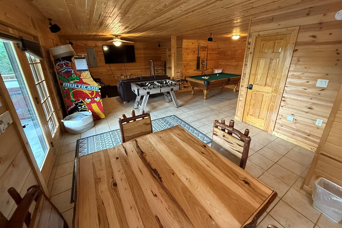 Game Room from a different angle in back where see Game Table, Large Screen TV, Foosball, Pool Table, Arcade games