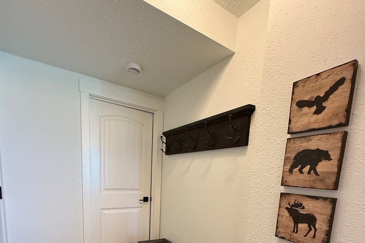Open Concept Entry: A spacious and welcoming entrance area featuring decorative wooden hooks for quick access to jackets and gear.