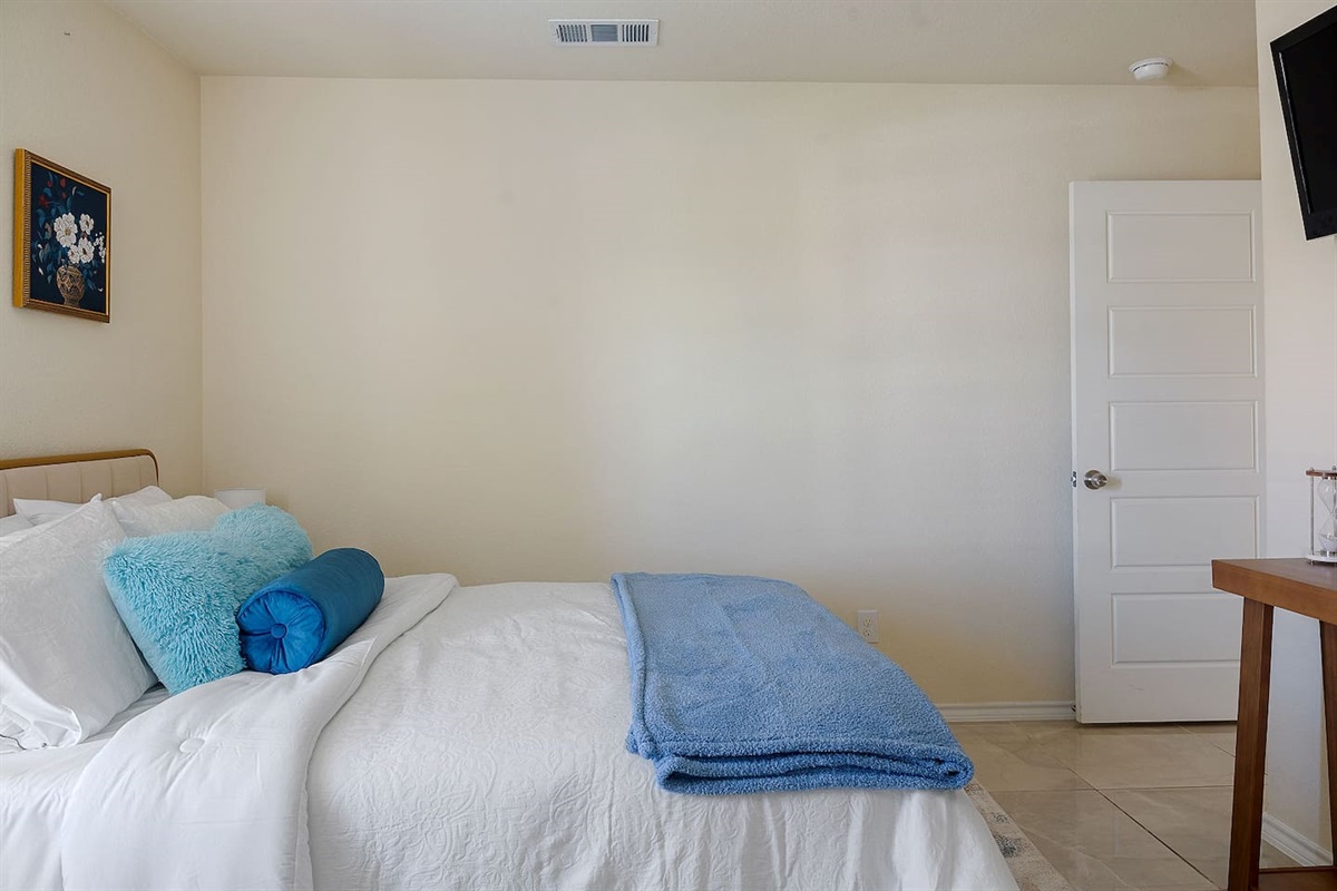 Enter this comfortable bedroom that includes a modern oak console for your convenience and a TV positioned on the wall.