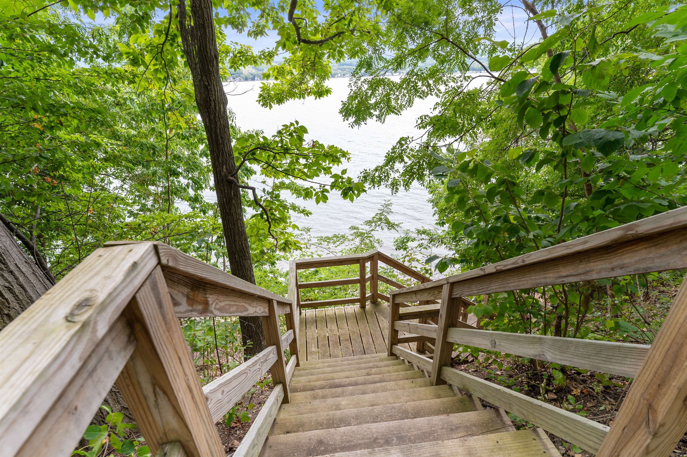 Scenic wooden stairs lead you through the trees to the shoreline, offering a serene start to every lake day.