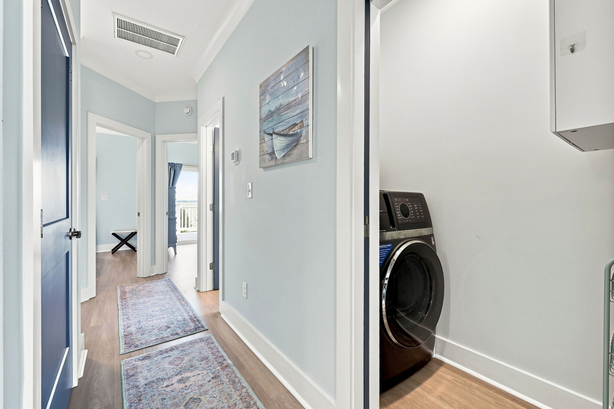 Convenient second-floor hallway featuring easy access to the laundry area and bedrooms with a bright, coastal-inspired design