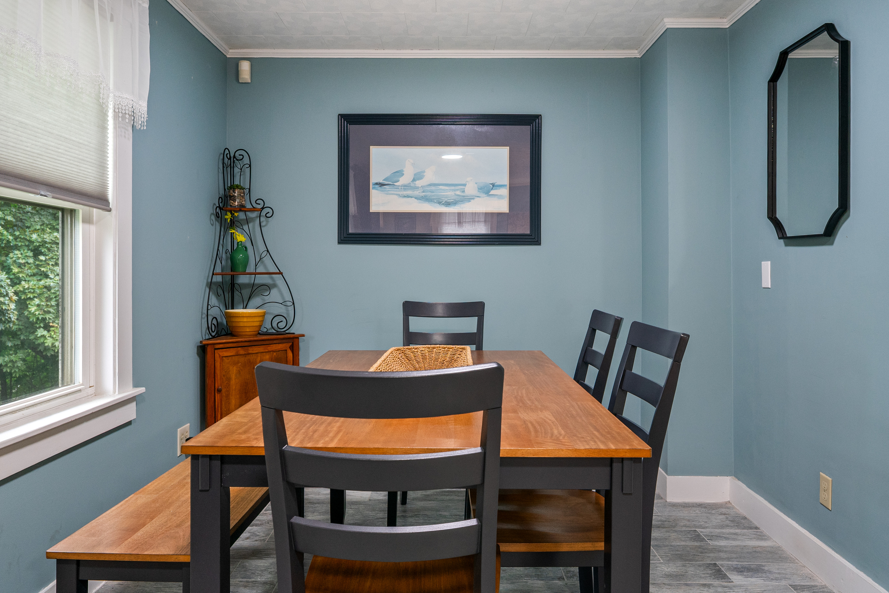 Gather your group around the large dining table for a home-cooked lobster bake or a lively game night. With a mix of classic wooden chairs and a long bench, this cozy, coastal-themed space is built for sharing meals and making Maine memories.