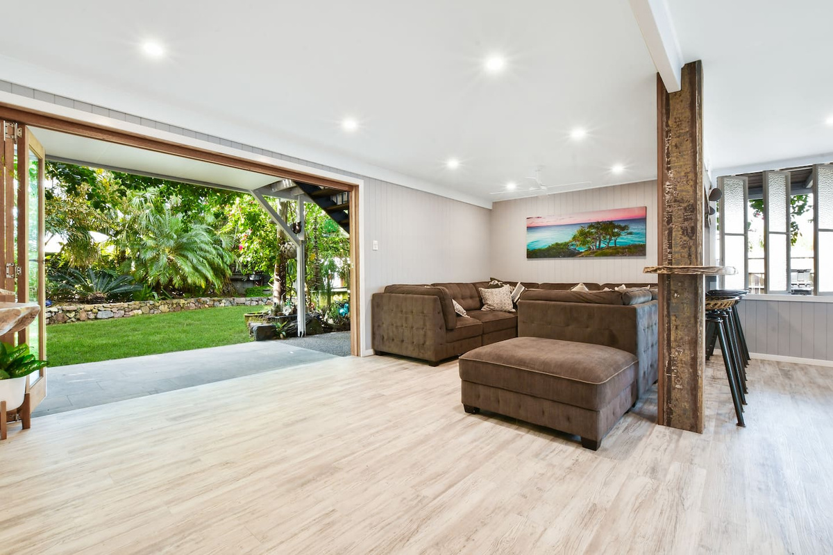 The full-width garden opening gives this lounge at Aaron's Beachside Boat House an airy, open feel with tropical greenery forming the backdrop.