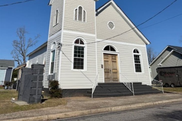 Charming historic church façade with traditional white siding and a signature steeple. Ideally situated near Downtown Augusta hotspots, the Medical College of Georgia, and local event venues. Generous on-site parking makes arrival easy.