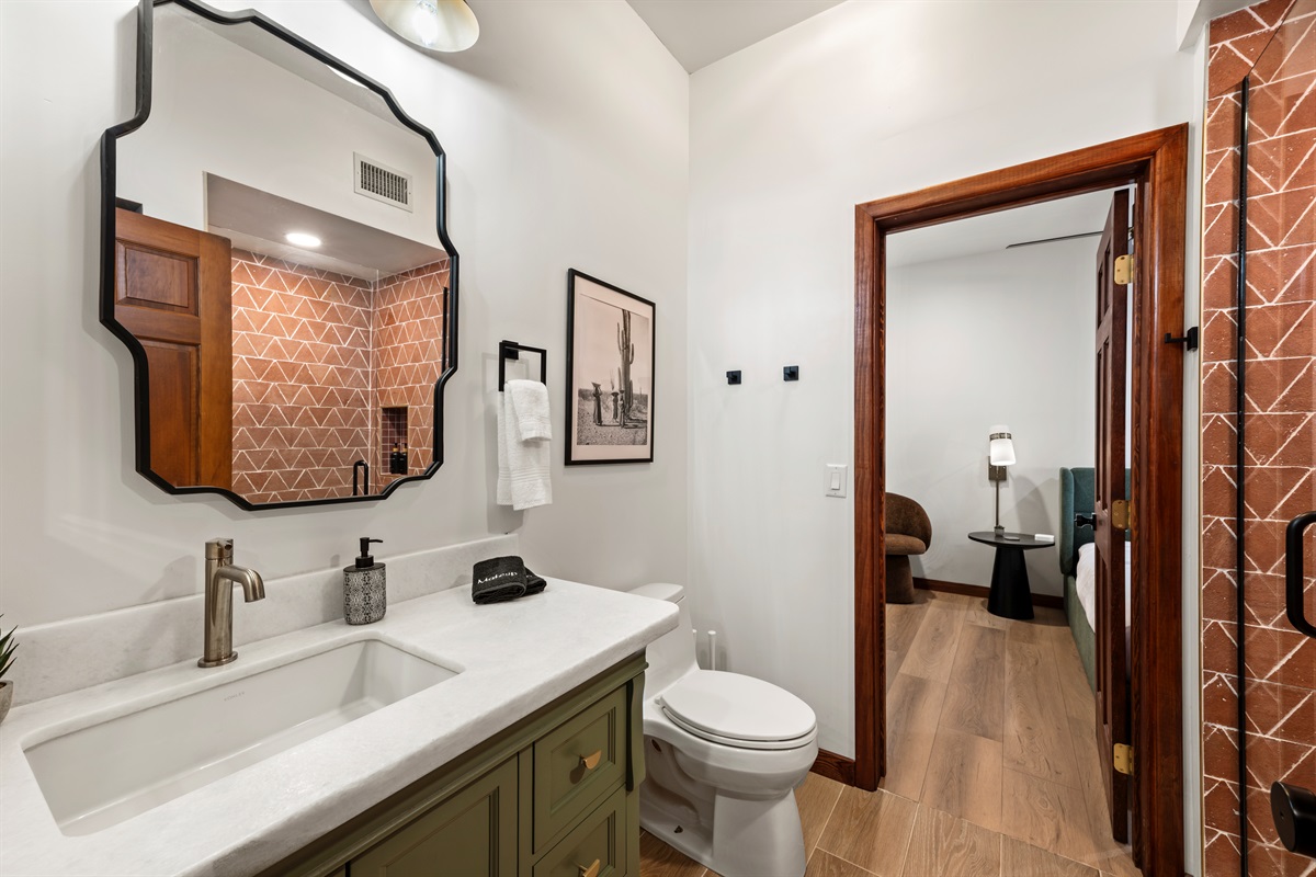 Modern bathroom with walk-in shower and custom tile detail.