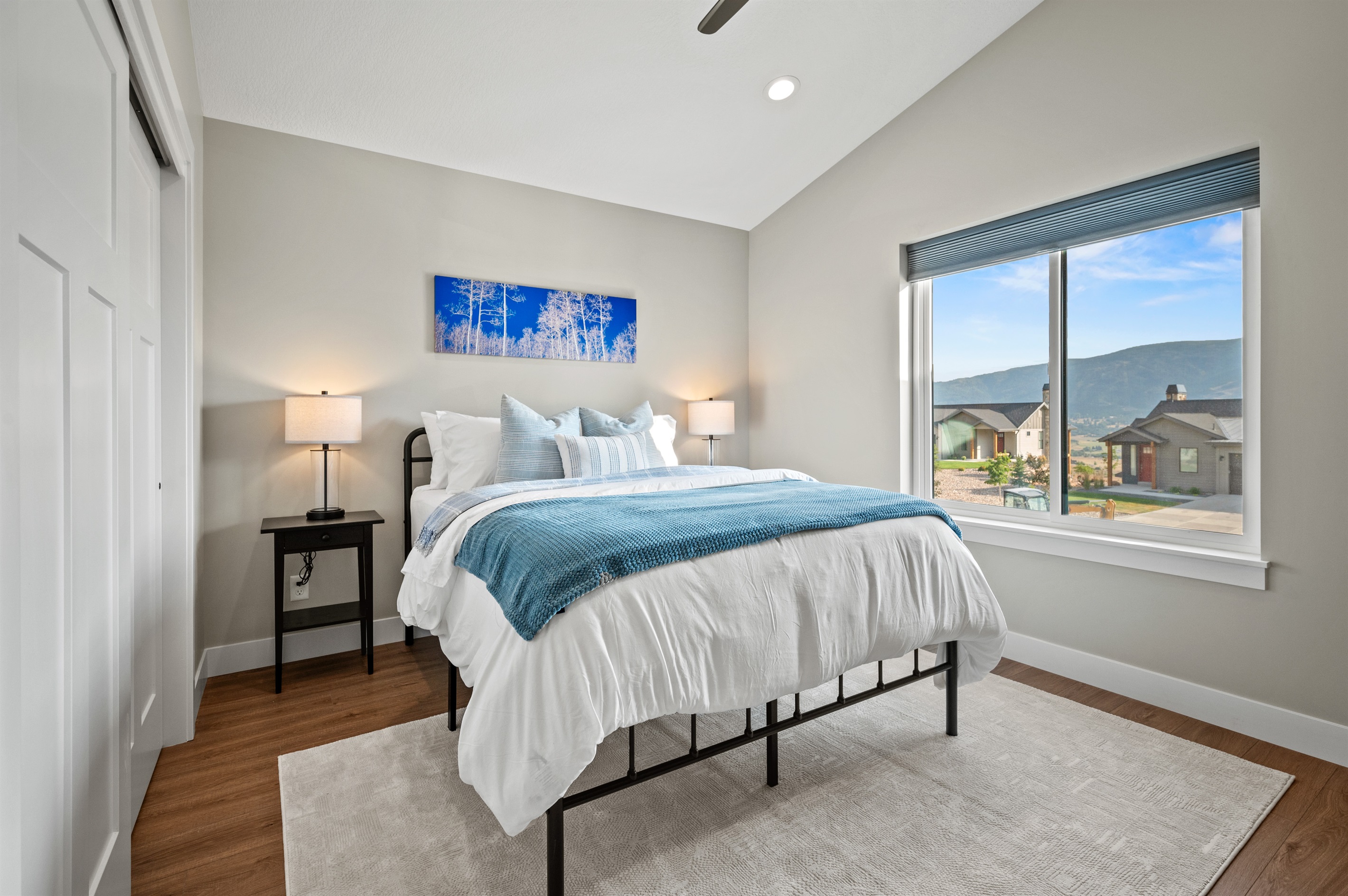 Beautifully appointed bedroom featuring stunning mountain views and a cooling ceiling fan for year-round comfort.