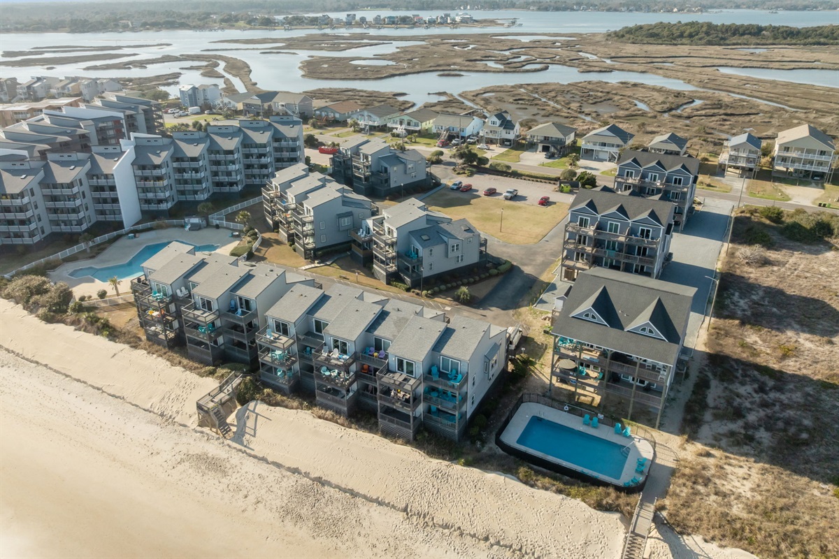 Wide aerial perspective of North Topsail Beach showcasing the oceanfront buildings, marshlands, and nearby homes