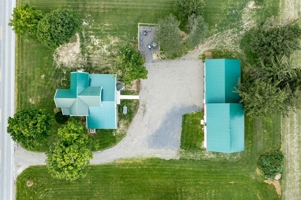 Bird’s-eye view of a well-maintained rural retreat with a long driveway, expansive lawn, and plenty of privacy from neighboring homes.