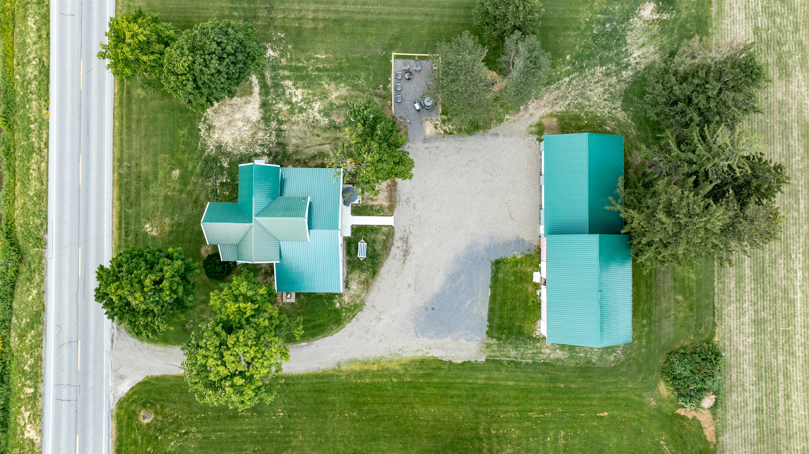 Bird’s-eye view of a well-maintained rural retreat with a long driveway, expansive lawn, and plenty of privacy from neighboring homes.