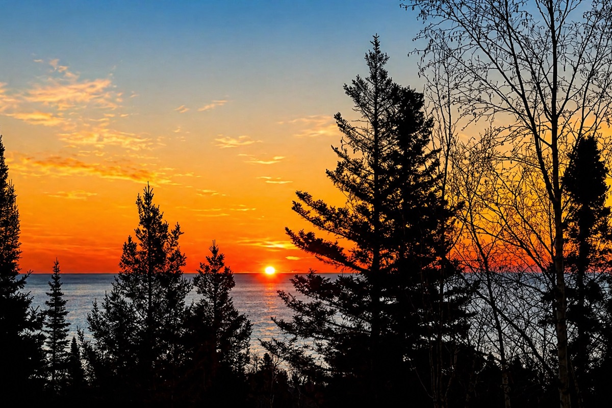 Wake up slowly at Treetops and step out onto the deck with a warm cup of coffee in your hand as the sun begins to rise over Lake Superior. The first light peeks through the trees, glowing softly between the branches before spilling out across the water.
