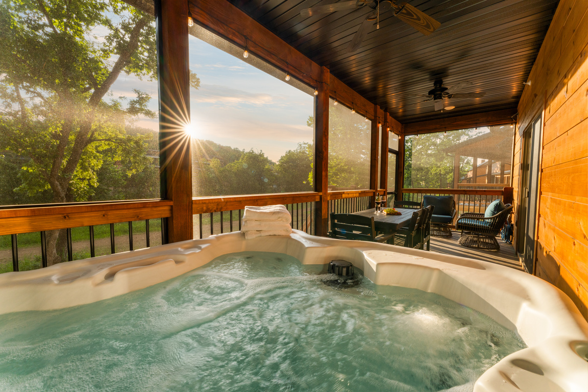 Sink into the bubbling hot tub as the sun sets through the trees on a screened-in-porch.