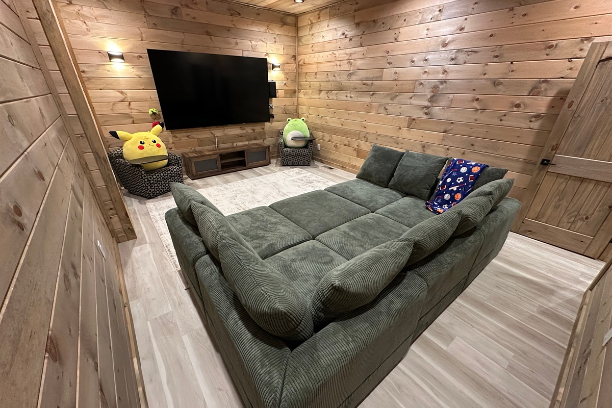 A cozy hangout made for movie nights and downtime. Plush seating, warm wood walls, and a big screen create the perfect spot for kids to unwind or for late night lounging after a full day outdoors.