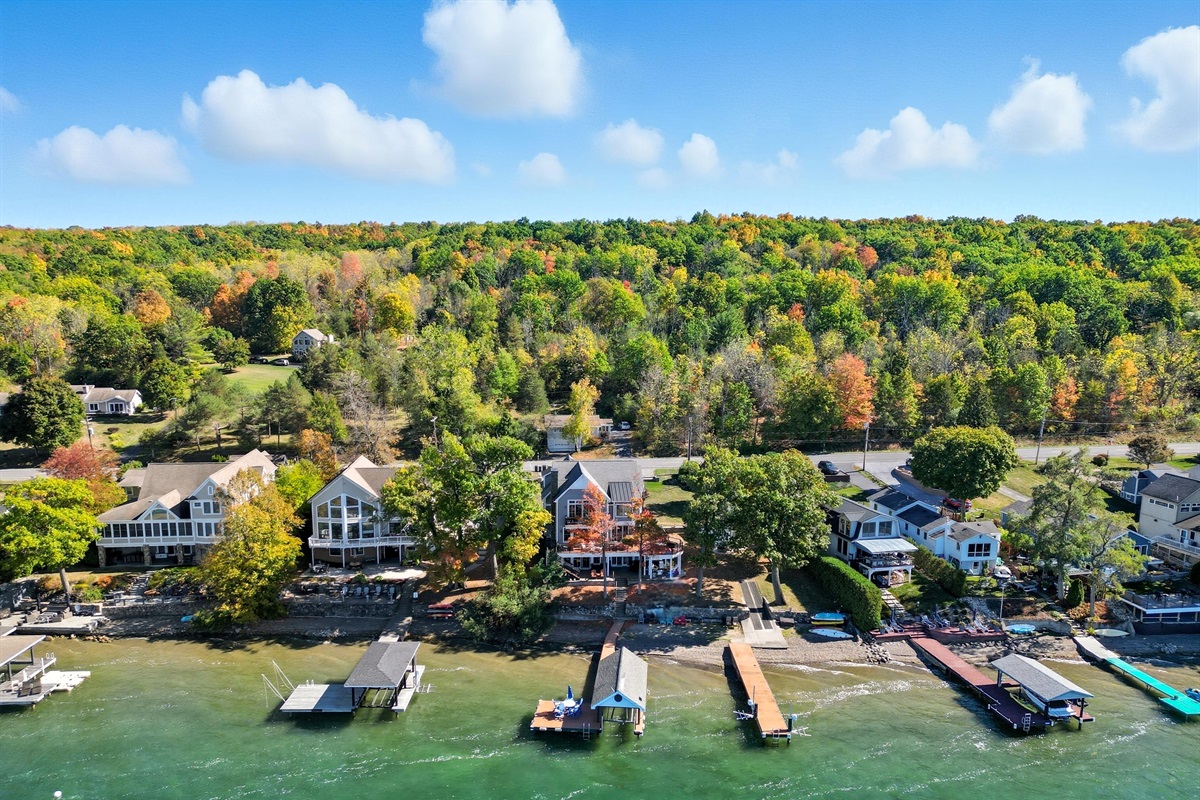 Drone view of lakeside neighborhood and colorful fall foliage.