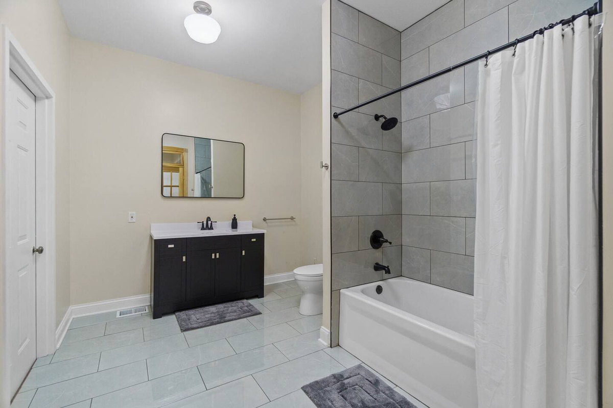 Full bathroom with modern fixtures, a spacious shower, and sleek finishes, providing a comfortable and functional space.