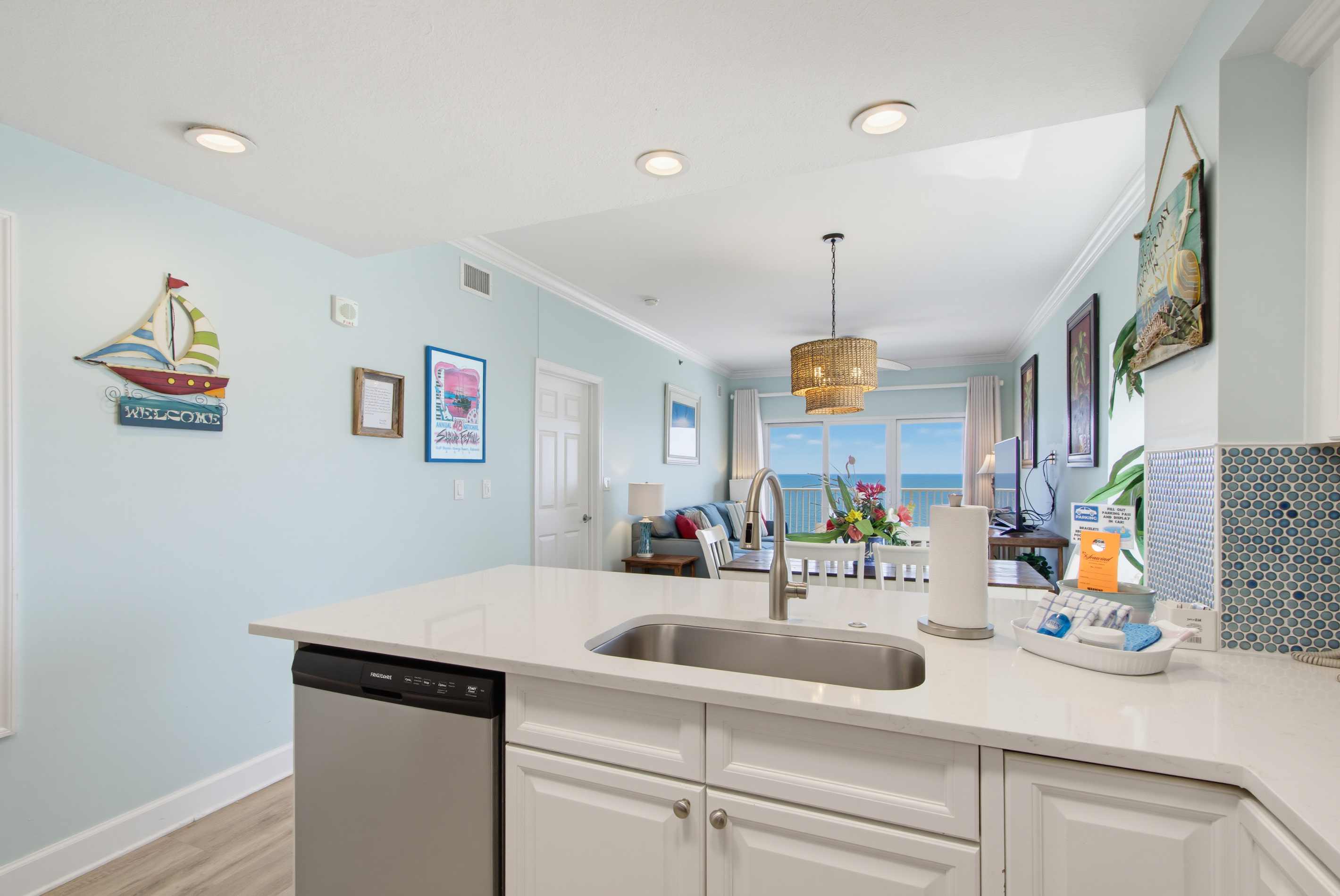Kitchen sink and breakfast bar overlooking the dining area and living room with a TV.