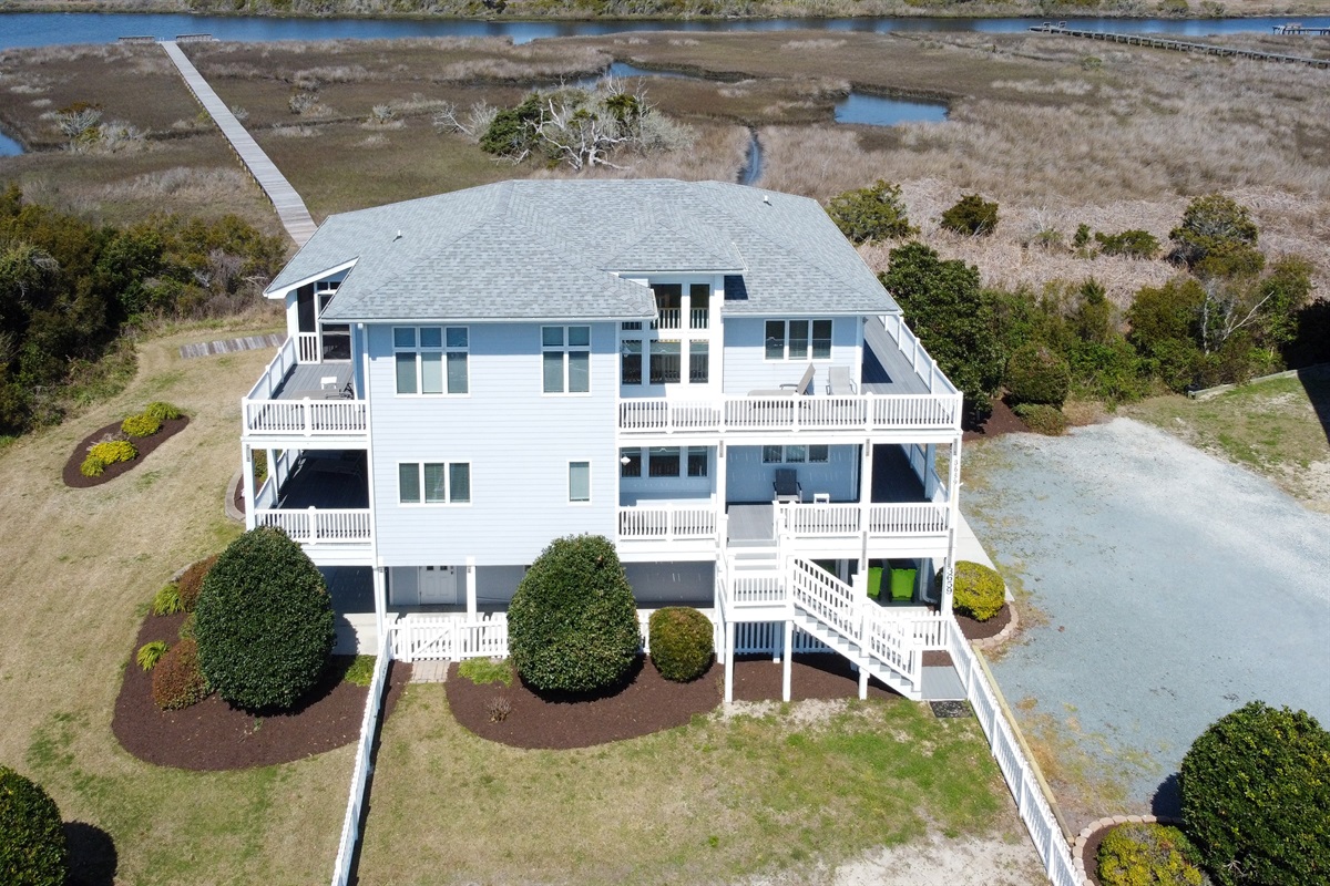 Rear view of the home with decks overlooking the marsh and sound