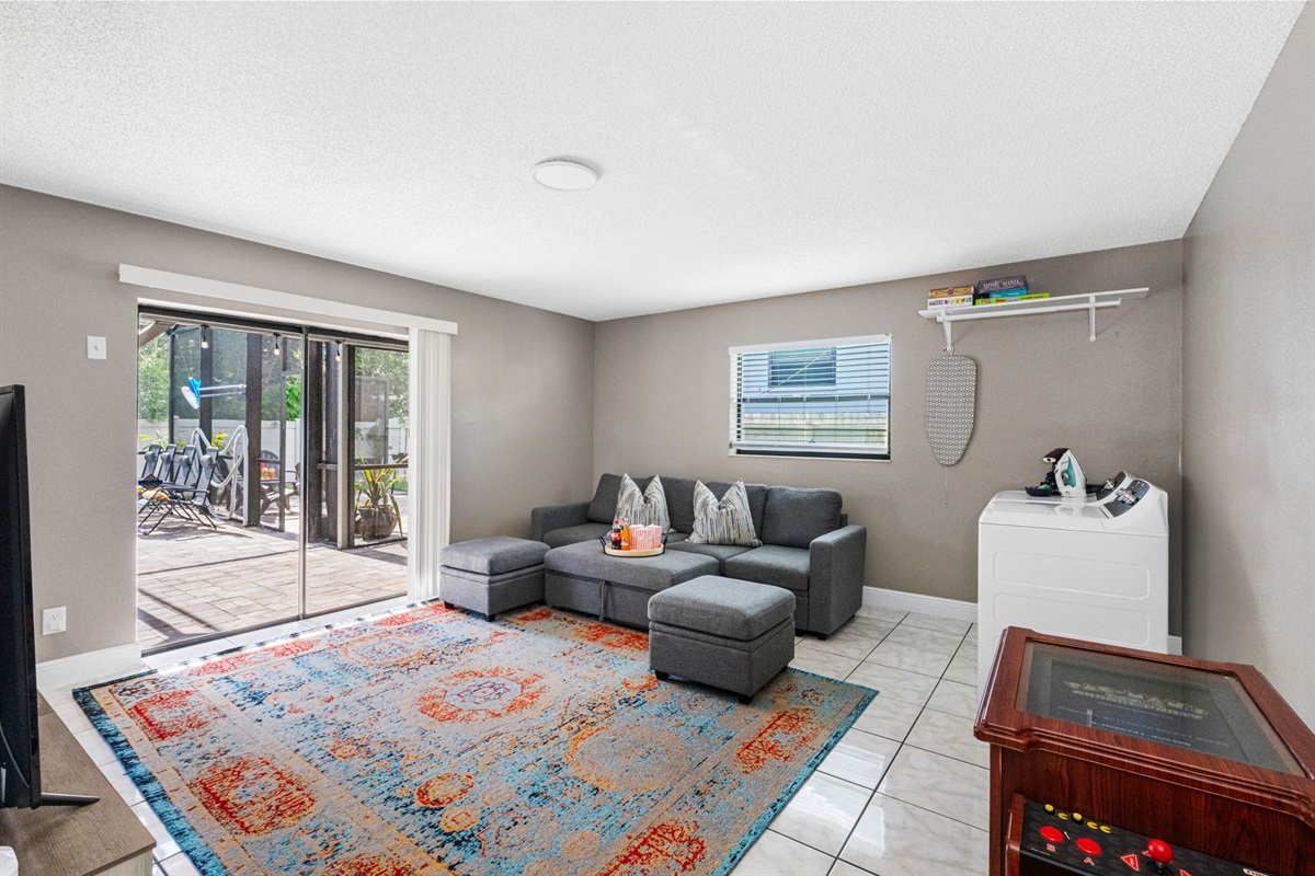 The room is bright and airy, thanks to a wide glass sliding door that leads directly to a screened patio—making indoor-outdoor living seamless.