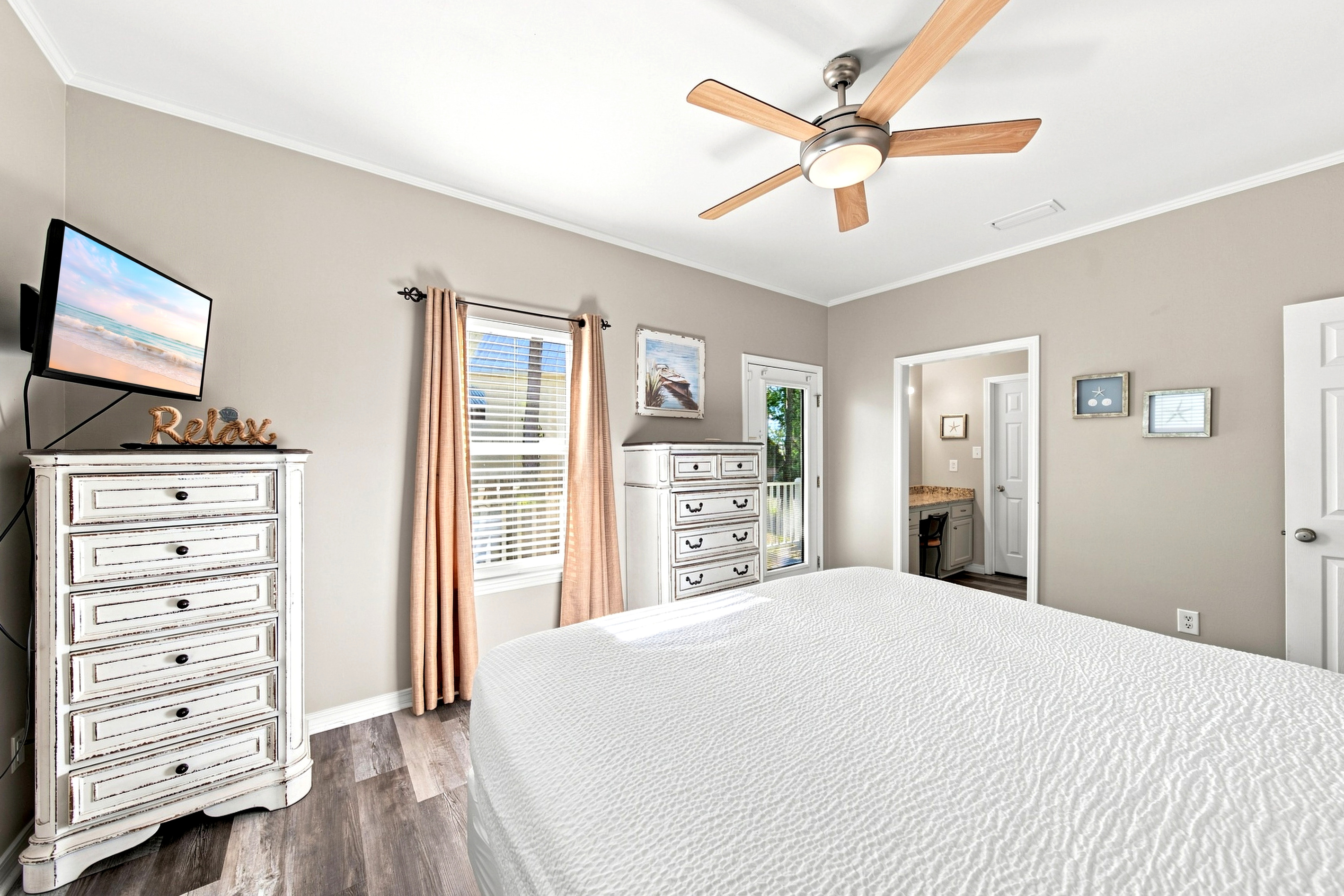 Another look at the upstairs guest bedroom, with a whitewashed dresser and warm coastal accents.