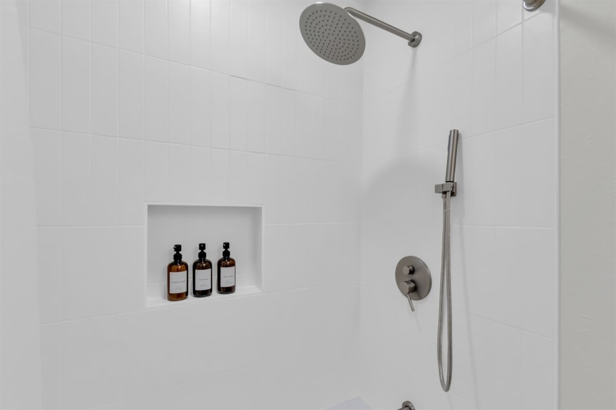 Modern rainfall shower with handheld attachment and premium Ginger Lily Farms toiletries. Enjoy relaxing hot water and a clean, bright design.