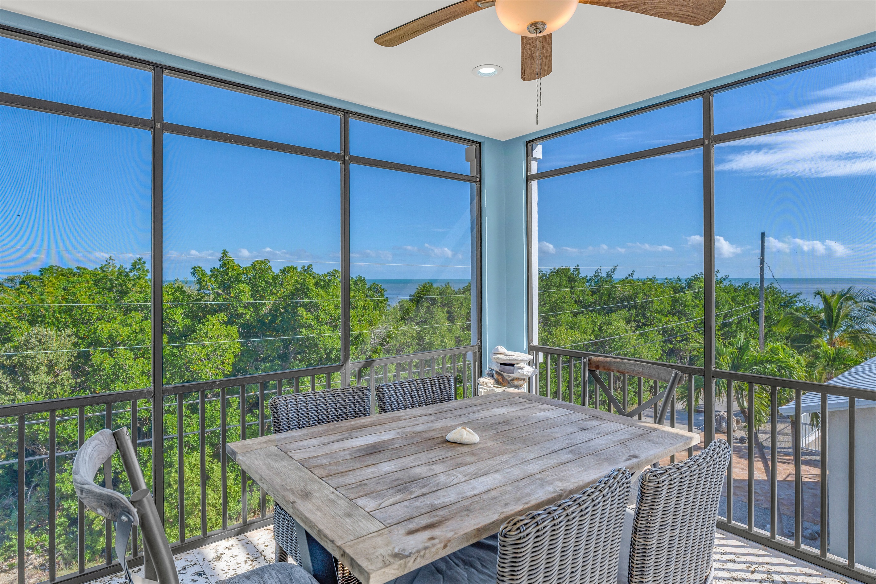 A screened in balcony right off the kitchen with ocean views.