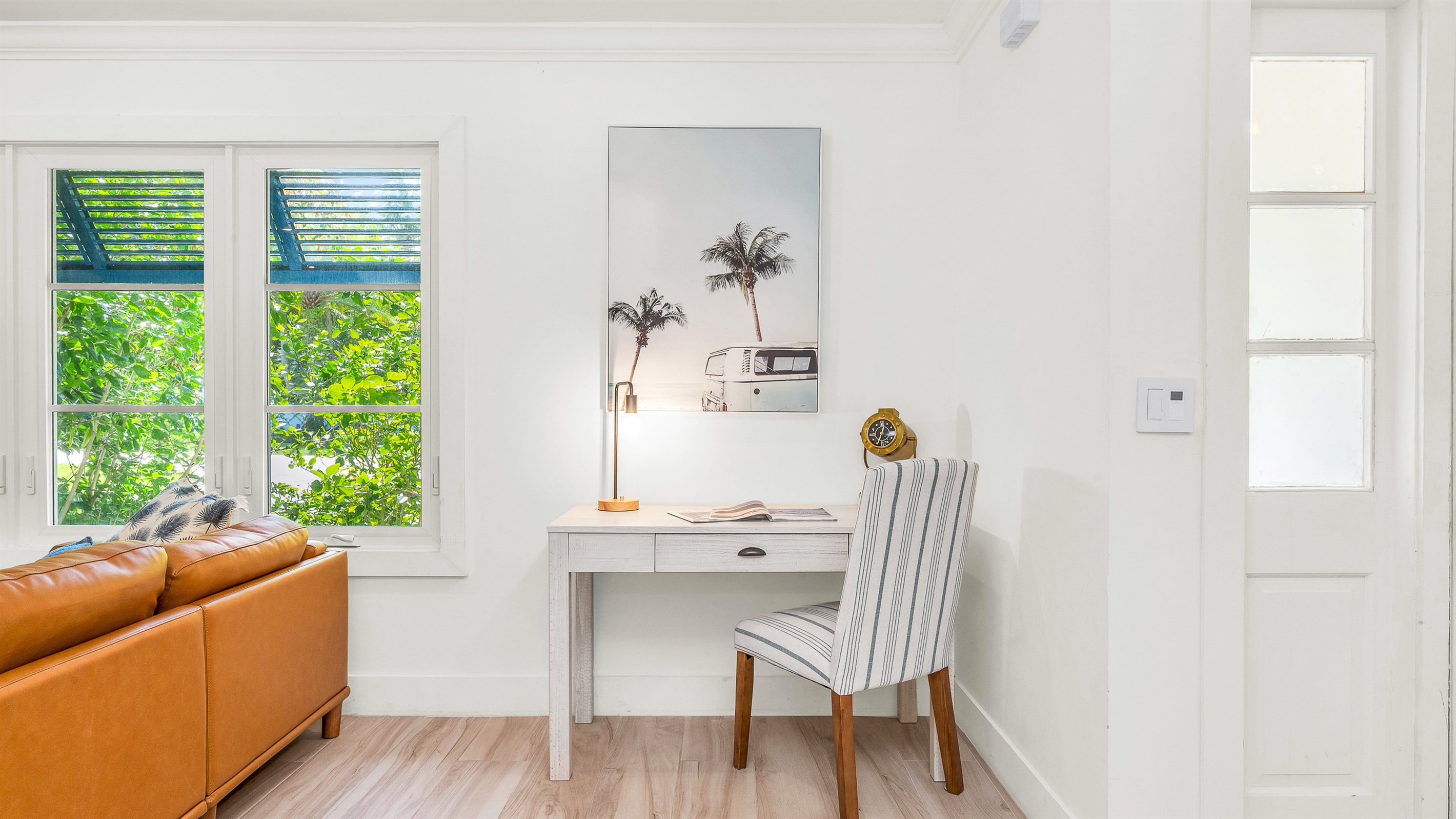 This bright and stylish workspace featuring a sleek modern desk and nautical-inspired decor, offers the perfect spot to stay productive while away from home, blending functionality with relaxed luxury,