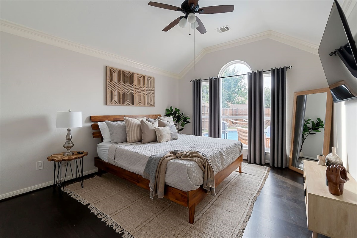 Embracing luxury and comfort in this spacious bedroom, where a king-size bed beckons amidst plush cushions. While glass window reveals a breathtaking view of the backyard pool area, creating a perfect blend of comfort and serenity.