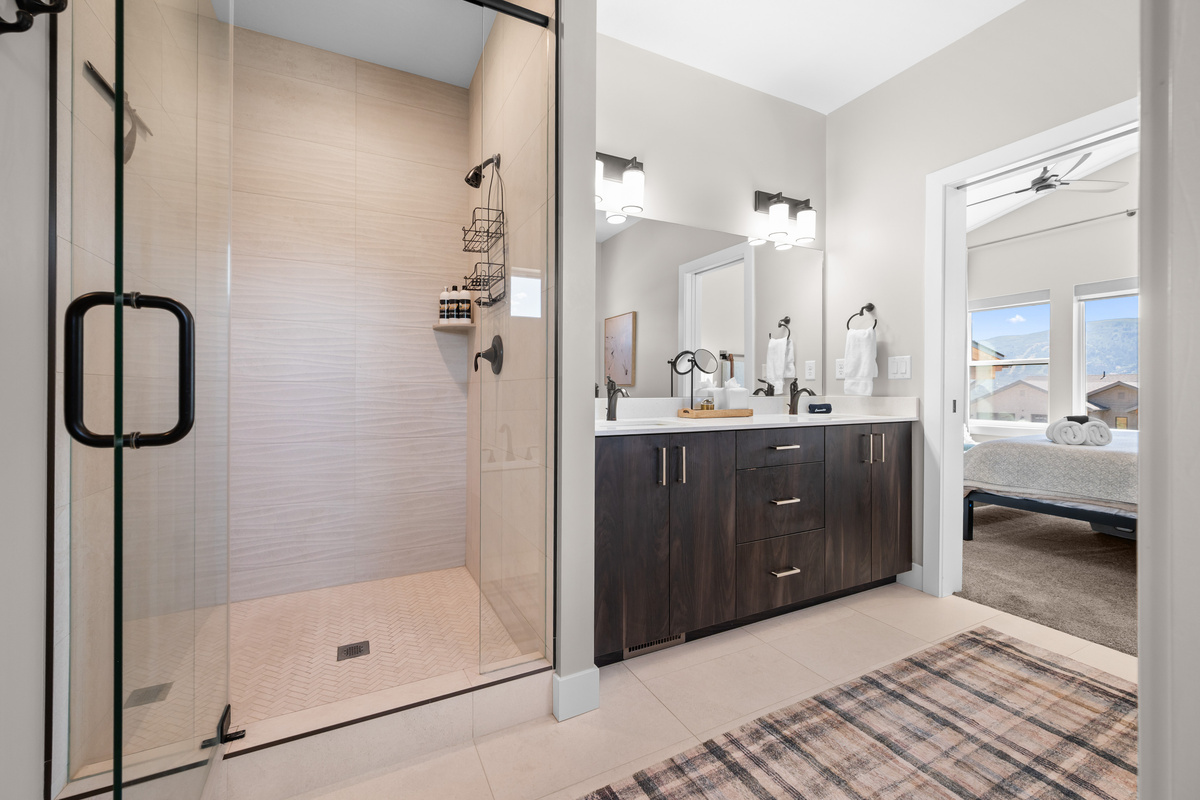 Elegant ensuite bathroom with a spacious walk-in shower, soaking tub, and direct access to the primary suite.