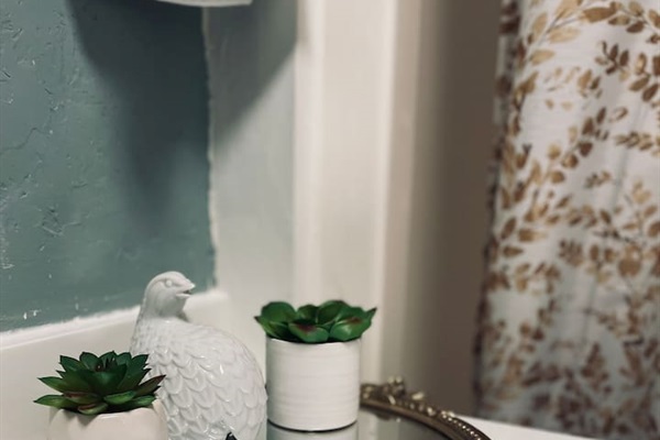 A delicate porcelain bird adds a touch of charm and character to the bathroom.