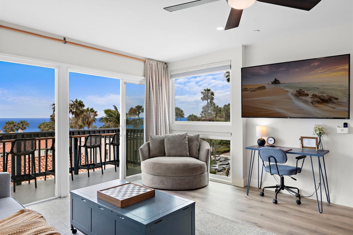 The living room has lots of comfortable seating, views and natural light pouring in from the balcony.