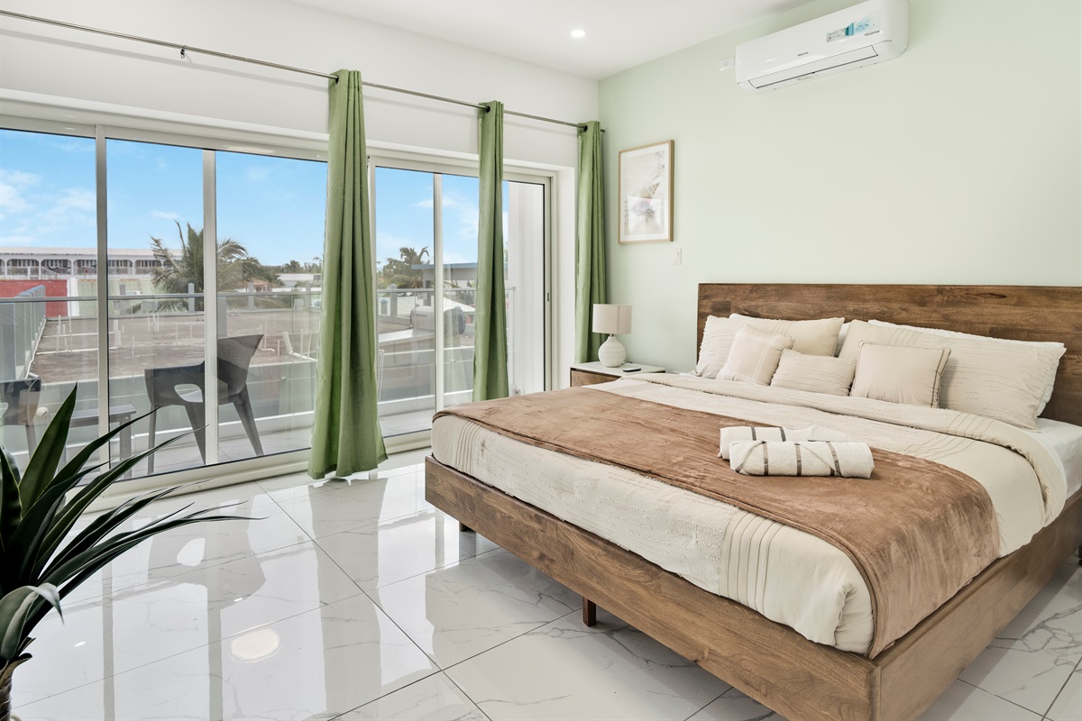 Sunlit King Bedroom with Neutral Tones & Balcony Access