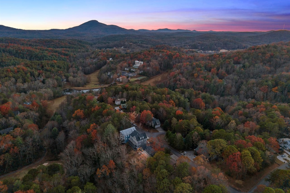 Twilight aerial view of the Helen property, with the mountains as a stunning backdrop—magical scenery from above.