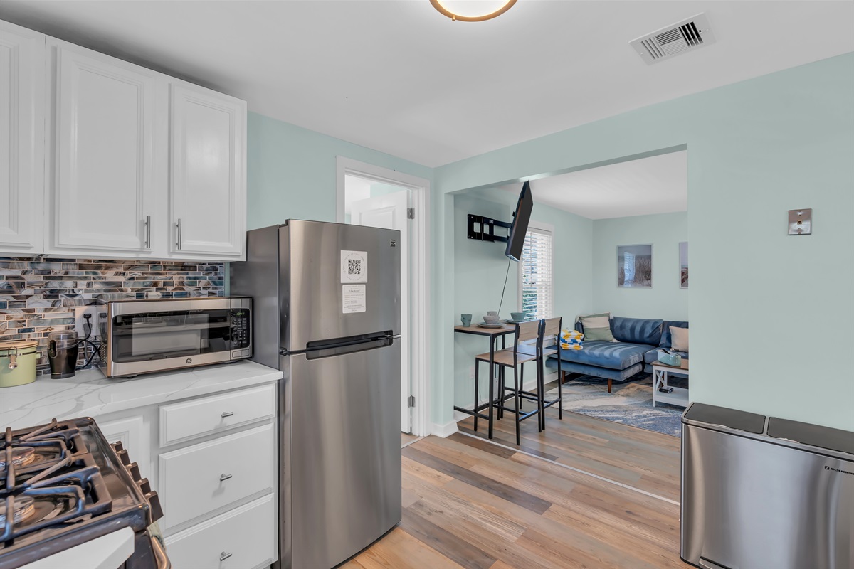 Modern beach apartment kitchen flows into cozy living space. Steps from Asbury Park's vibrant scene, perfect for couples and families. Experience Jersey Shore charm with all the comforts of home.